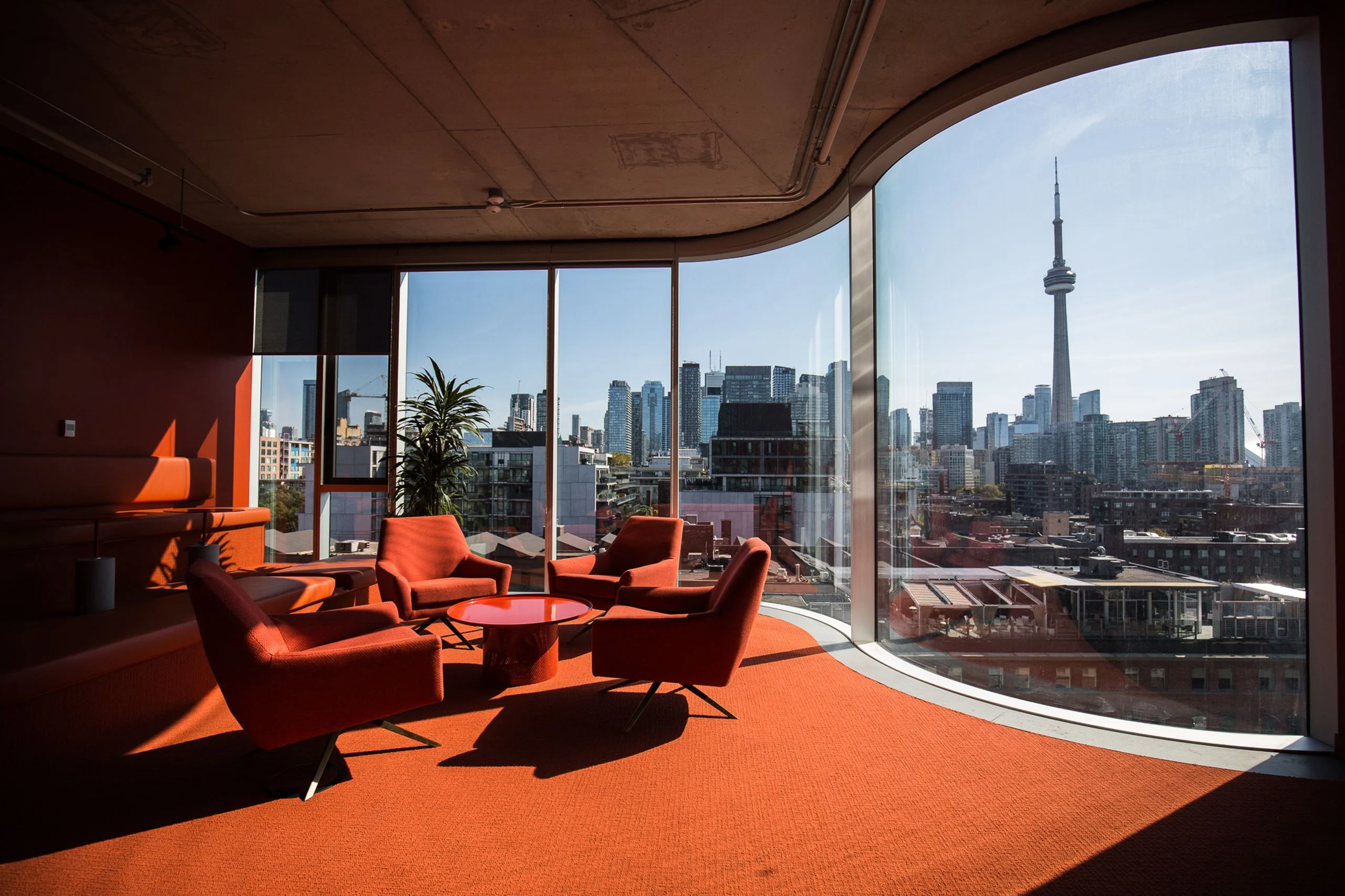 Shopify Toronto executive lounge with the CN Tower framed through curved glass